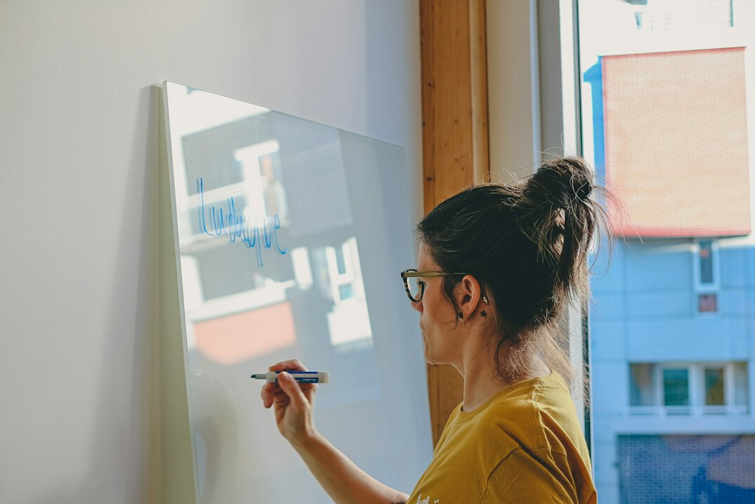 woman writing code on whiteboard