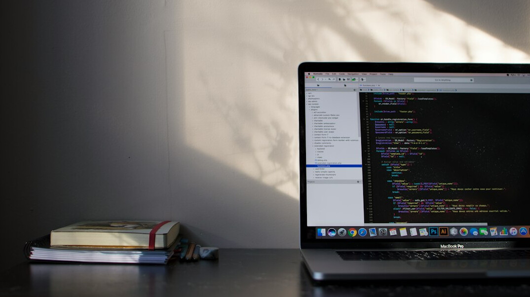 person coding on laptop